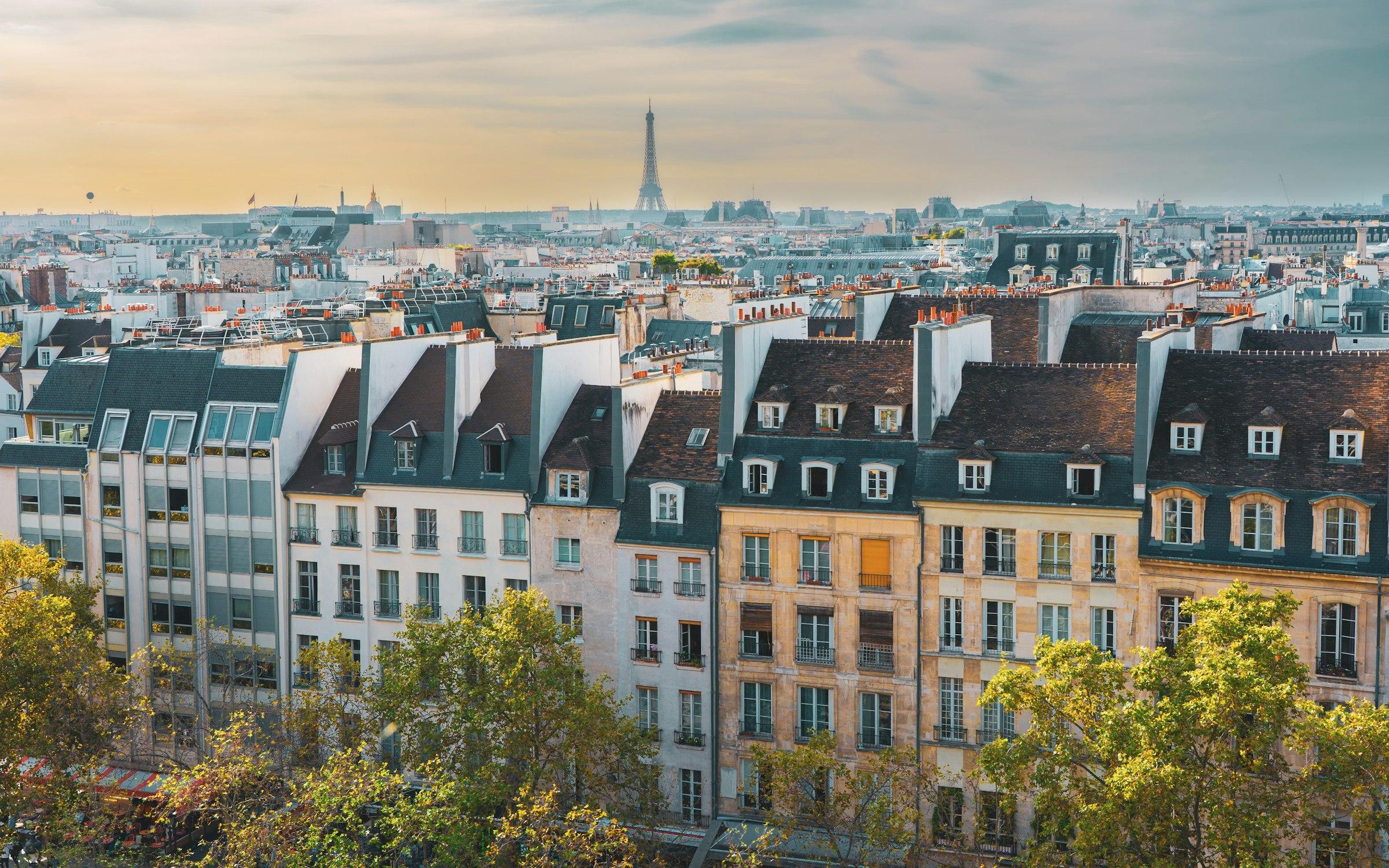 Panorama de Paris au coucher du soleil : les toits parisiens et la Tour Eiffel au loin